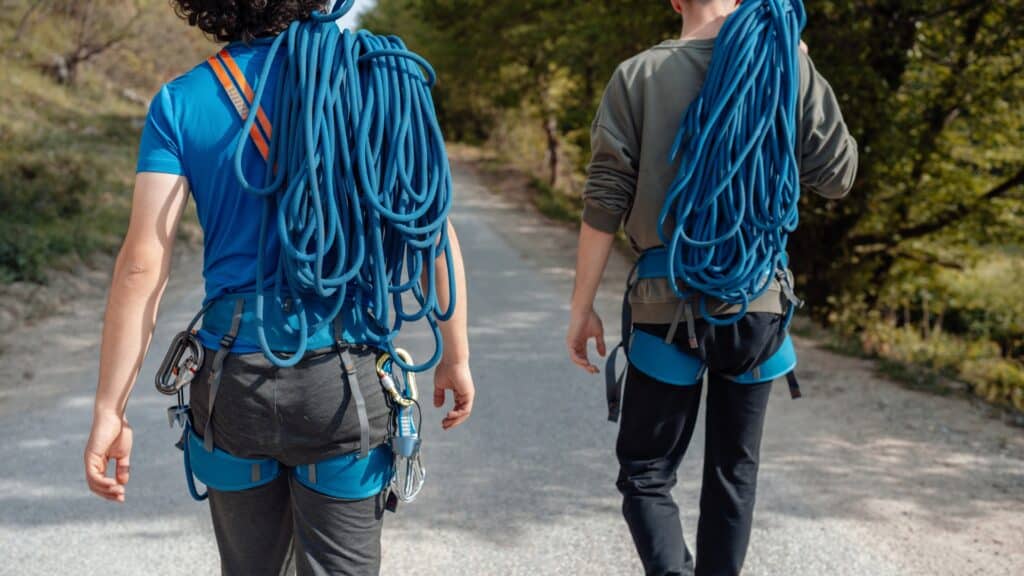 2 Menschen laufen auf einer Straße mit Kletterausrüstung