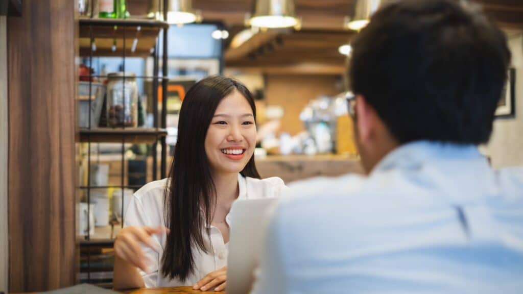 Junge asiatische Frau hat ein Geschäftsessen mit einem jungen Geschäftsmann