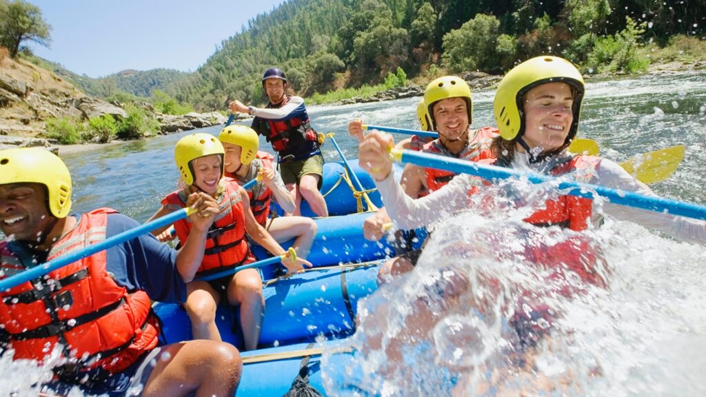 Wasser spritzt beim Rafting ins Boot