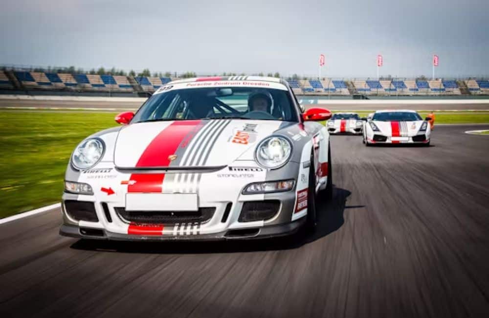 Porsche 911 auf einer Rennstrecke, weiß mit rotem Streifen