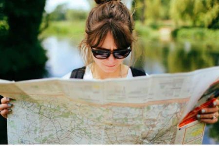 Frau mit Sonnenbrille schaut eine große Karte an
