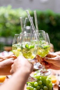 Teilnehmer stoßen mit erfrischenden Sommerdrinks und Weintrauben an – geselliger Auftakt zum Teambuilding mit Beachfeeling in entspannter Outdoor-Atmosphäre