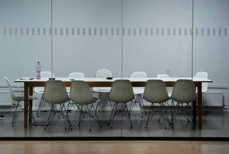 Büro-Meetingraum, monoton mit leeren Stühlen und einem Tisch