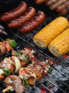 Saftige Grillspieße, Würste und Maiskolben auf dem Rost – kulinarischer Höhepunkt beim Teambuilding mit Beachfeeling am Riedsee.